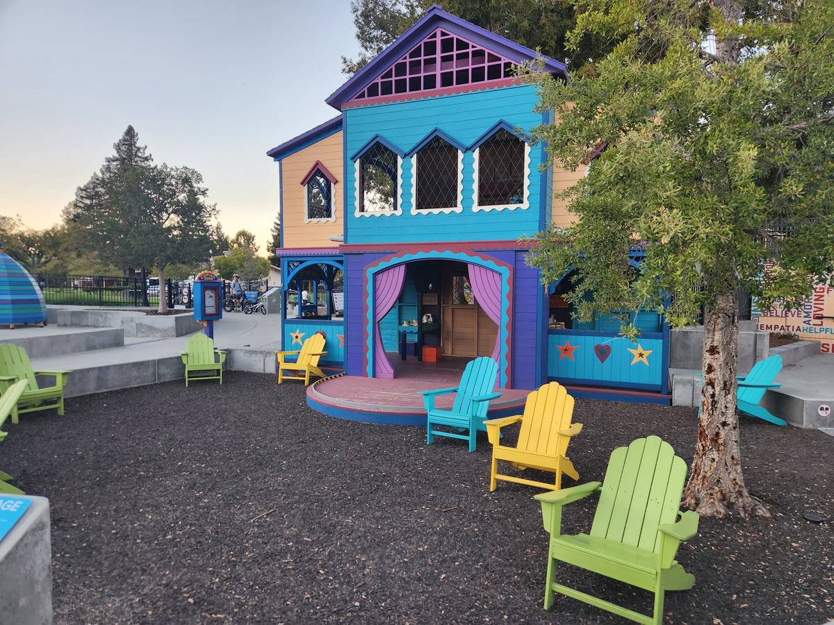 The purple and blue playhouse, with Adirondack chairs out front