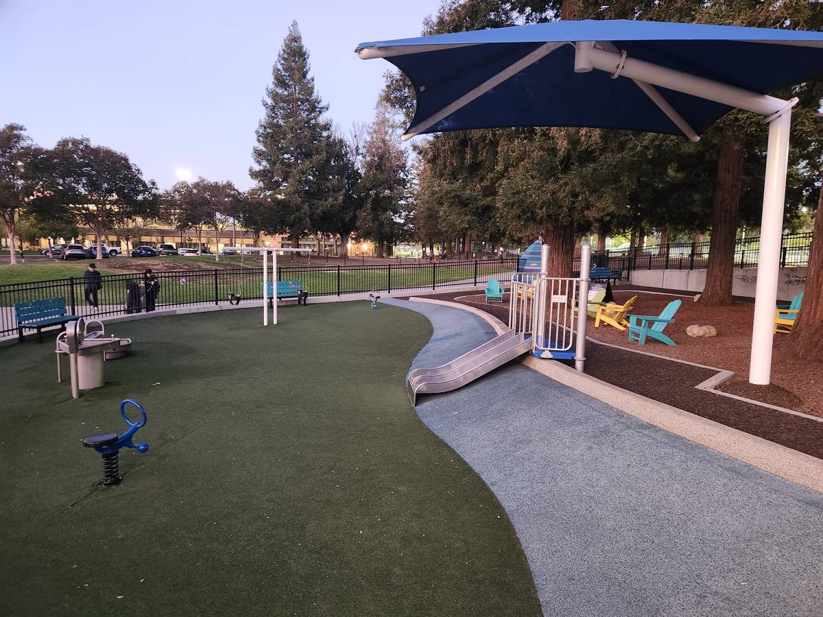 The toddler area: turf, a little slide, and a metal water basin